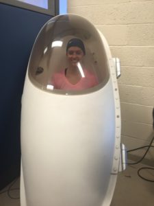 A women sits inside a Bod Pod machine