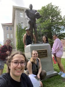 6 Individuals pose with a statue of Ernie Davis