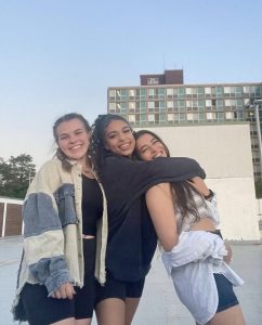3 women pose in front of a dorm